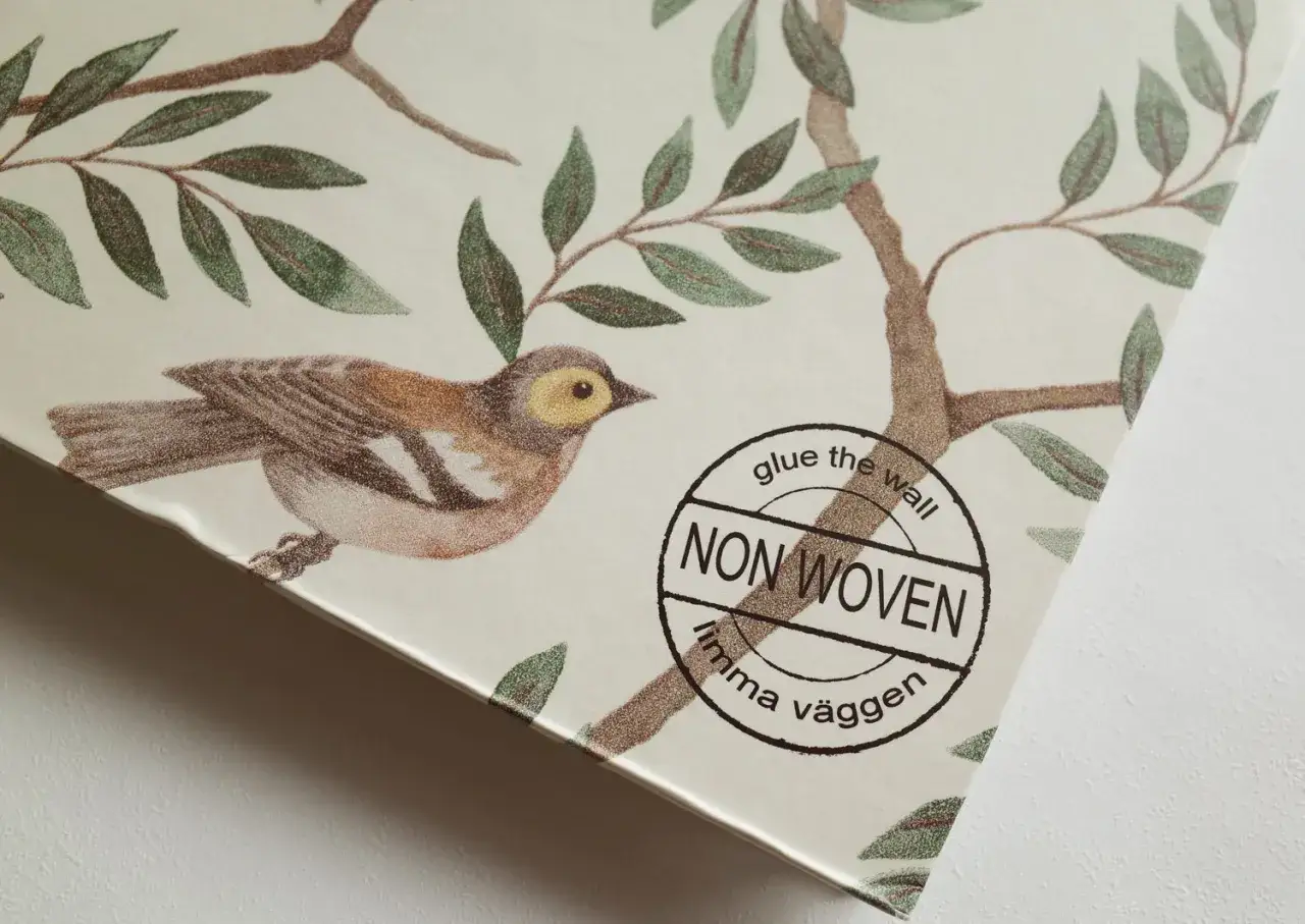 Detalj av tapetsera non woven med fågel och grenar. Texten